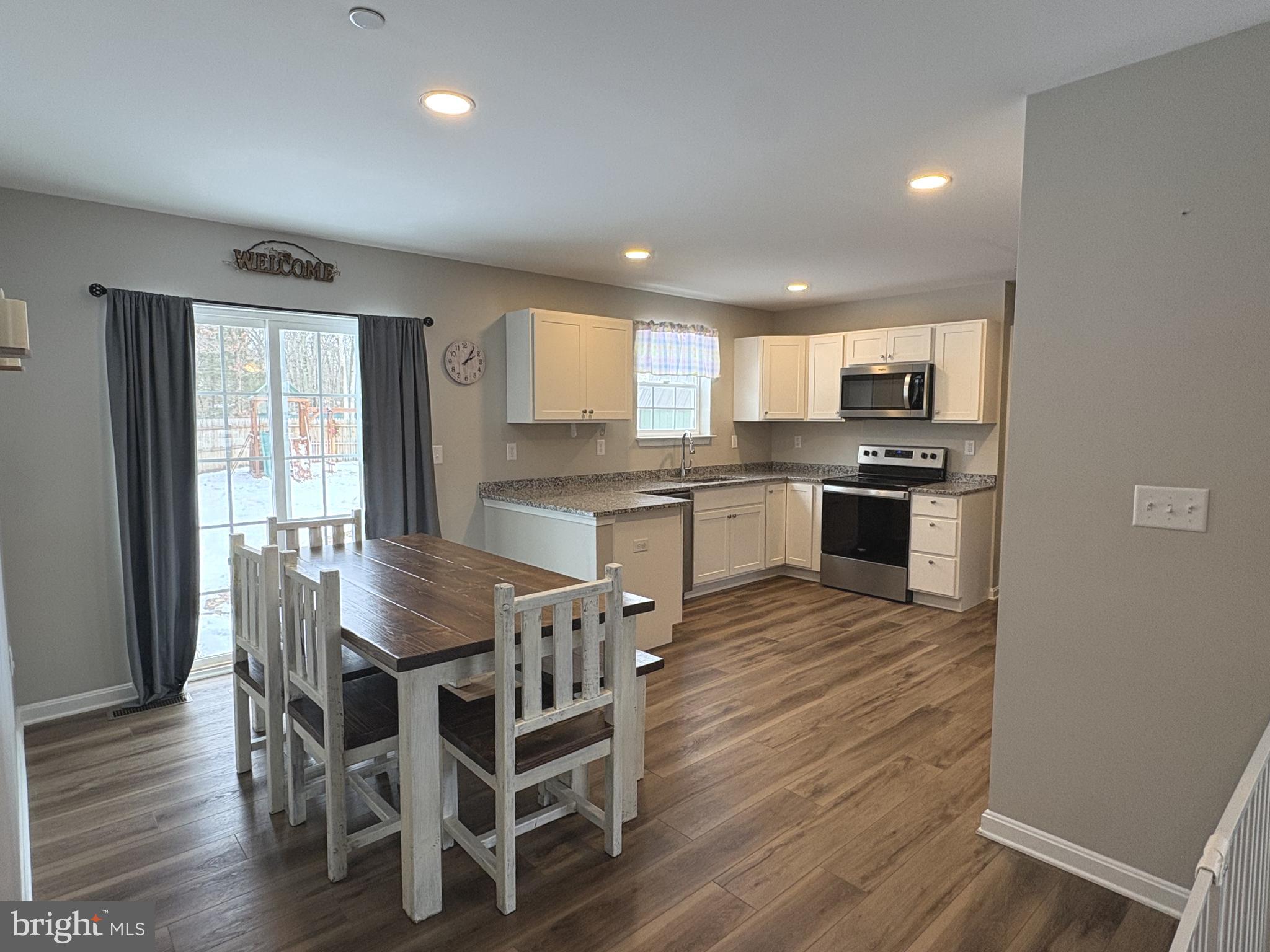148 East Step Road Chestertown, MD 21620 - Photo 8 of 46 a kitchen with stainless steel appliances granite countertop a kitchen island hardwood floor sink stove dining table and chairs