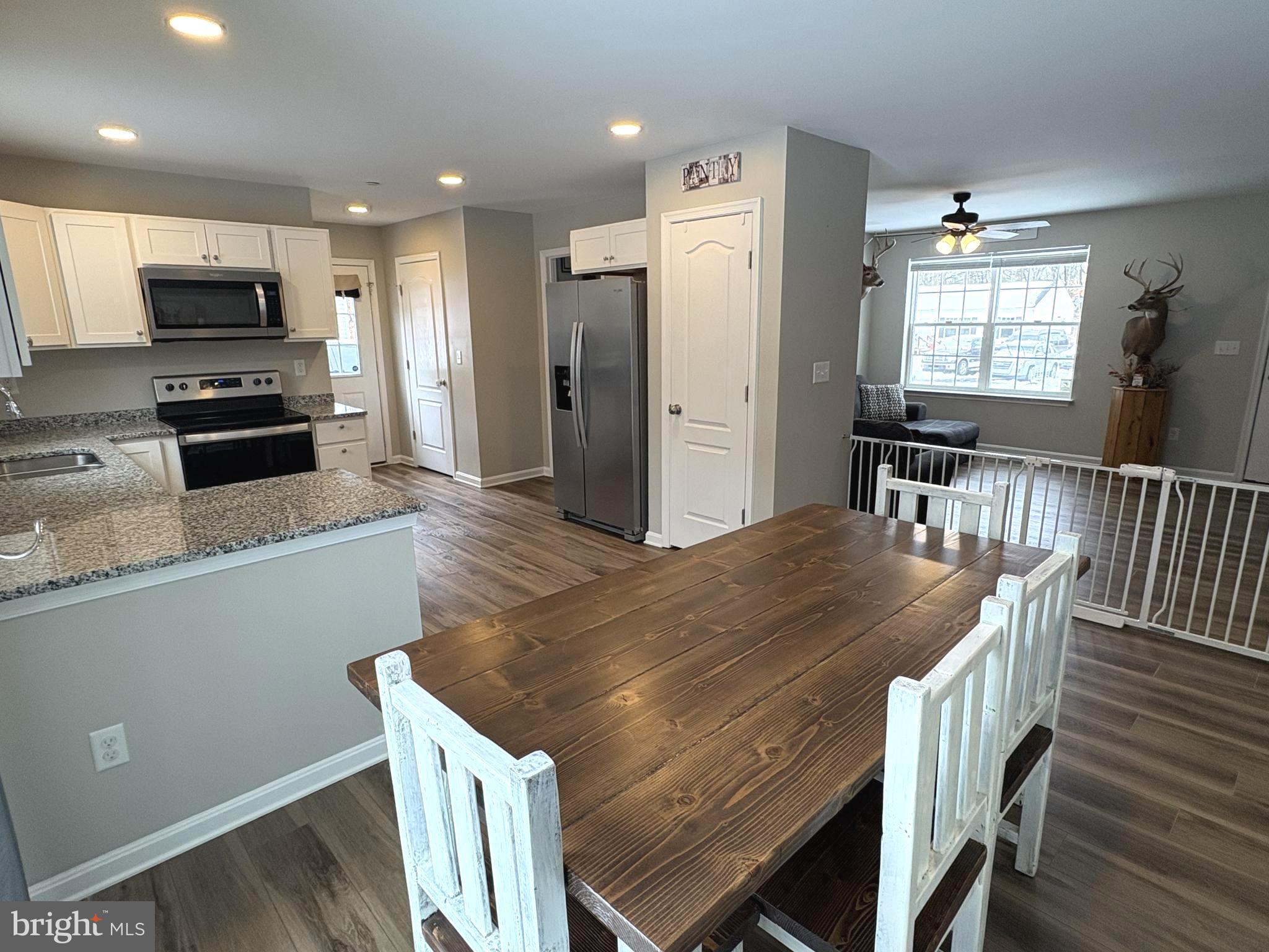 148 East Step Road Chestertown, MD 21620 - Photo 9 of 46 a kitchen with stainless steel appliances granite countertop a table chairs and a refrigerator
