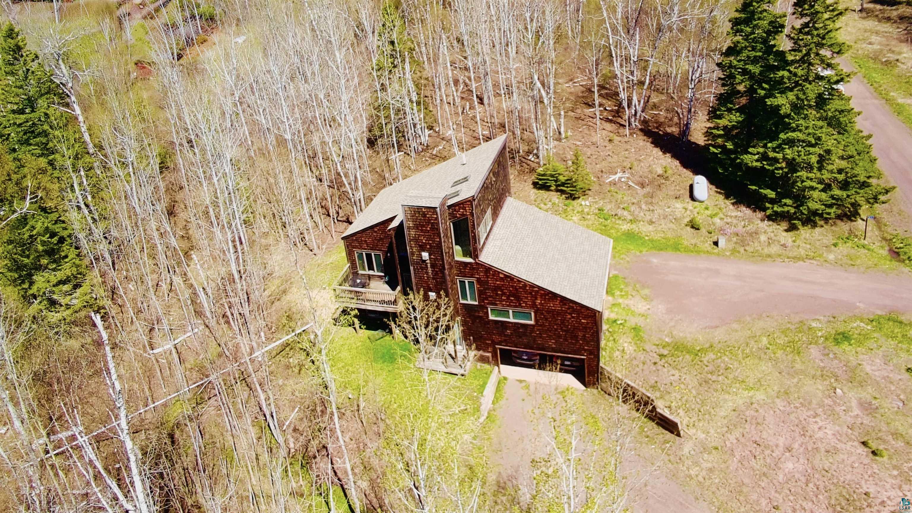 67 Snowshoe Trail Tofte, MN 55615 - Photo 3 of 42 Modern architectural residence featuring a prominent shingled exterior and multi-level roofline