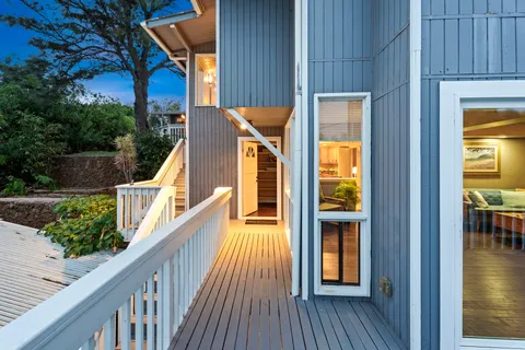 a view of balcony with two chairs and wooden floor