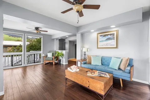 a living room with furniture and a wooden floor