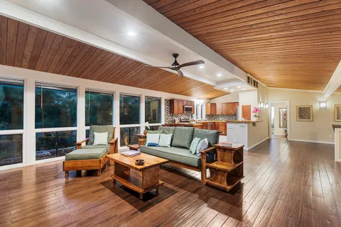 a living room with furniture and a wooden floor