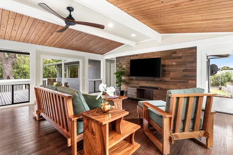 a living room with furniture a flat screen tv and a table