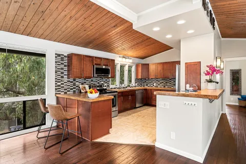 a kitchen with stainless steel appliances kitchen island granite countertop a stove and cabinets