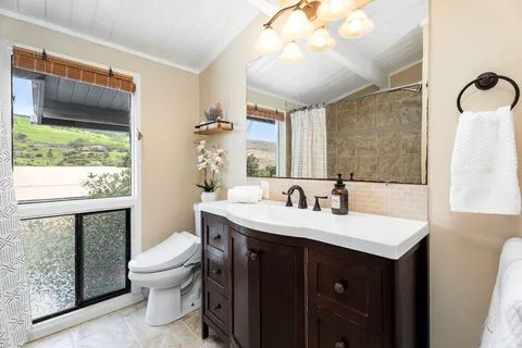 a bathroom with a sink vanity mirror and toilet