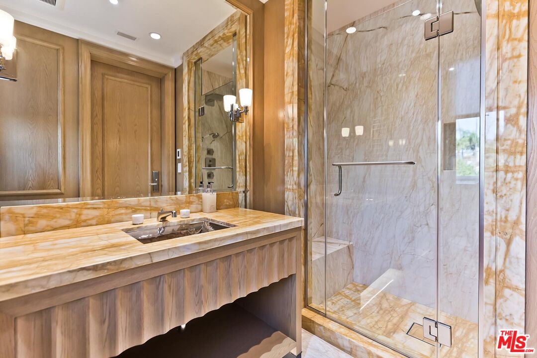 610 North Rodeo Drive Beverly Hills, CA 90210 - Photo 21 of 38 a bathroom with a granite countertop sink and a mirror