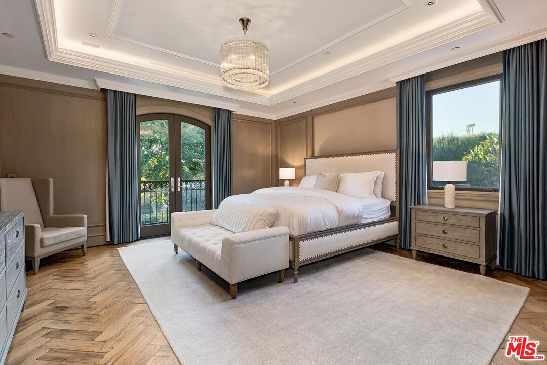 610 North Rodeo Drive Beverly Hills, CA 90210 - Photo 27 of 38 a spacious bedroom with a large bed and a chandelier