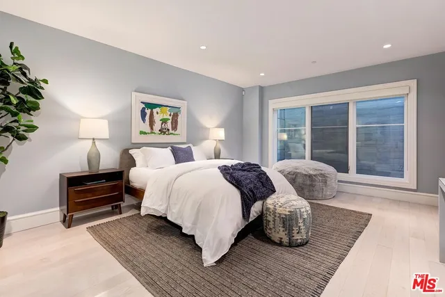 a bedroom with a bed and a large window