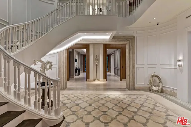 a view of a hallway with wooden chairs and stairs