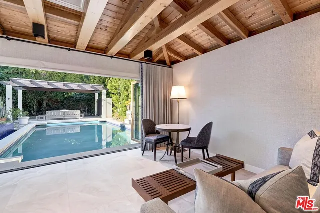 a view of a patio with dining table and chairs with a floor to ceiling window