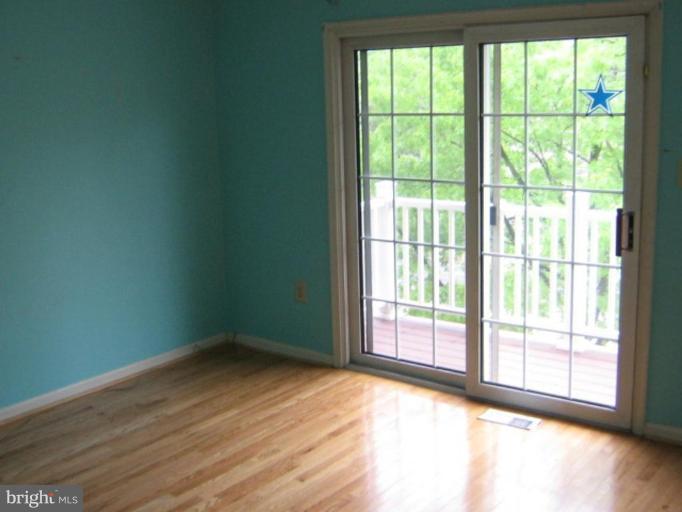 3062 South Glebe Road, Unit 3062 Arlington, VA 22206 - Photo 4 of 9 a view of an empty room with wooden floor and a window
