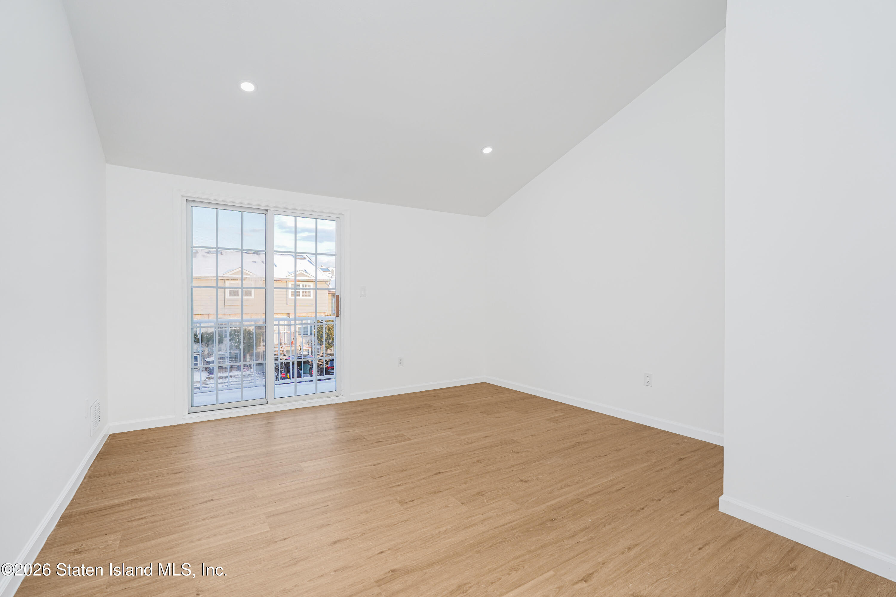 48 Studio Lane Staten Island, NY 10304 - Photo 20 of 38 an empty room with wooden floor and windows