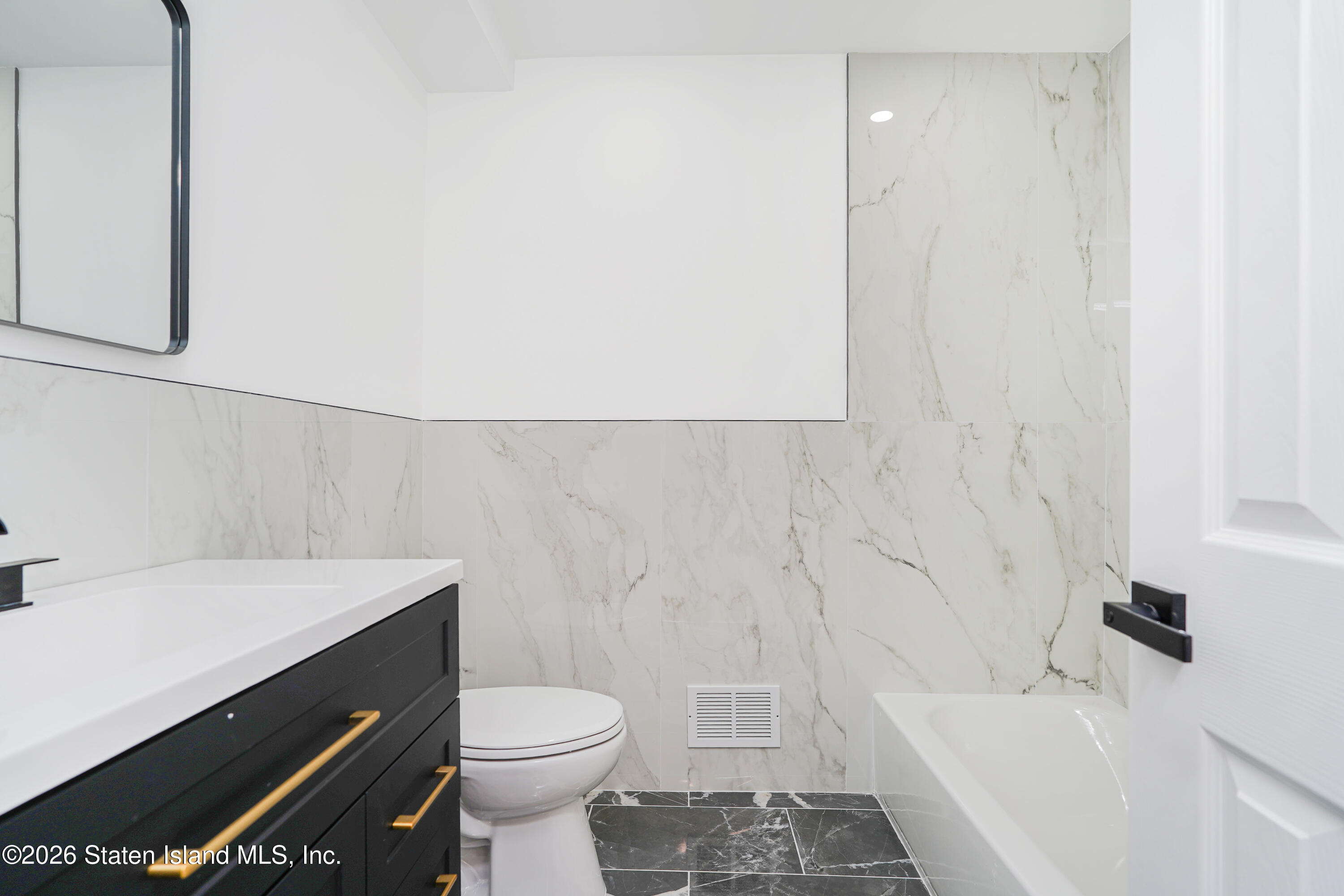 48 Studio Lane Staten Island, NY 10304 - Photo 22 of 38 a bathroom with a sink a toilet and shower