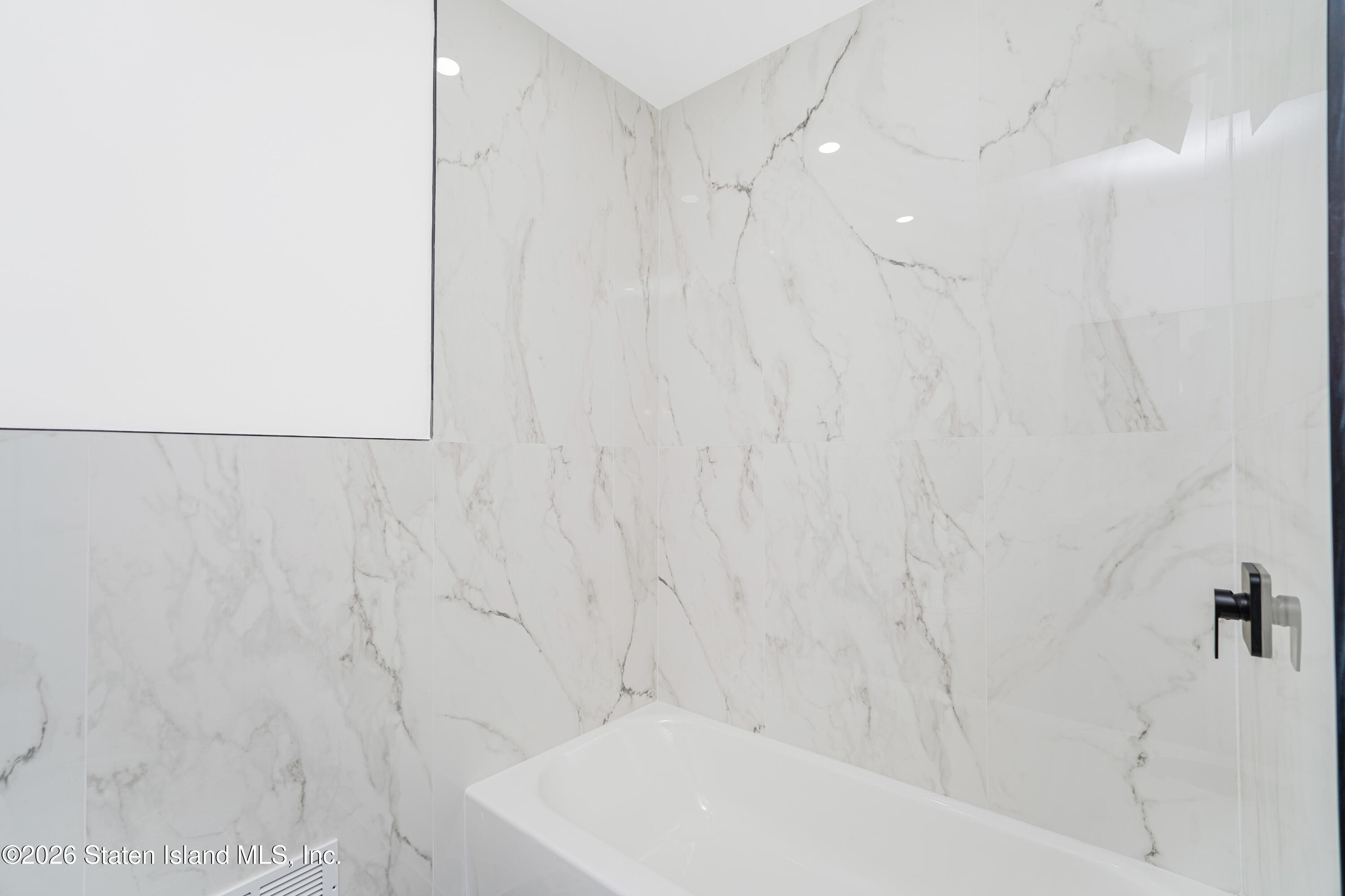 48 Studio Lane Staten Island, NY 10304 - Photo 23 of 38 a bathroom with a white bathtub and a shower