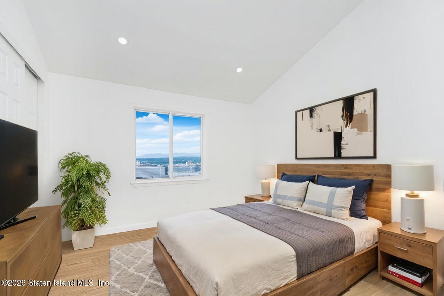 48 Studio Lane Staten Island, NY 10304 - Photo 35 of 38 a bedroom with a large bed and a potted plant