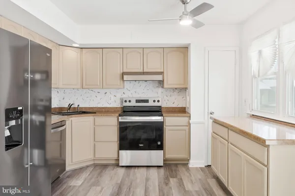 a kitchen with stainless steel appliances granite countertop a stove a sink and a refrigerator with cabinets