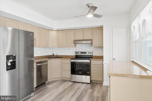 a kitchen with a refrigerator a stove a microwave and wooden floor