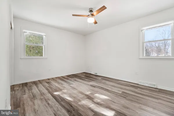 a view of room with hardwood floor and a ceiling fan