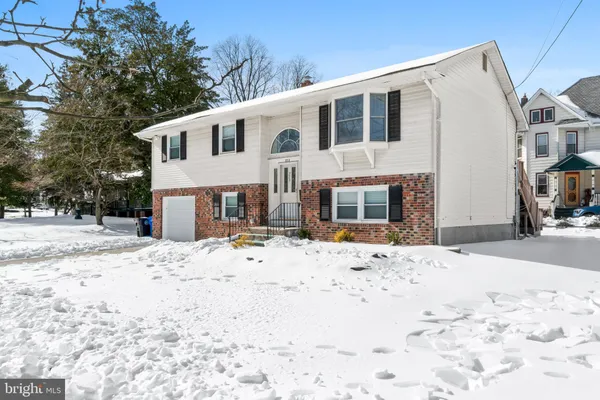 a front view of a house with a yard covered in snow