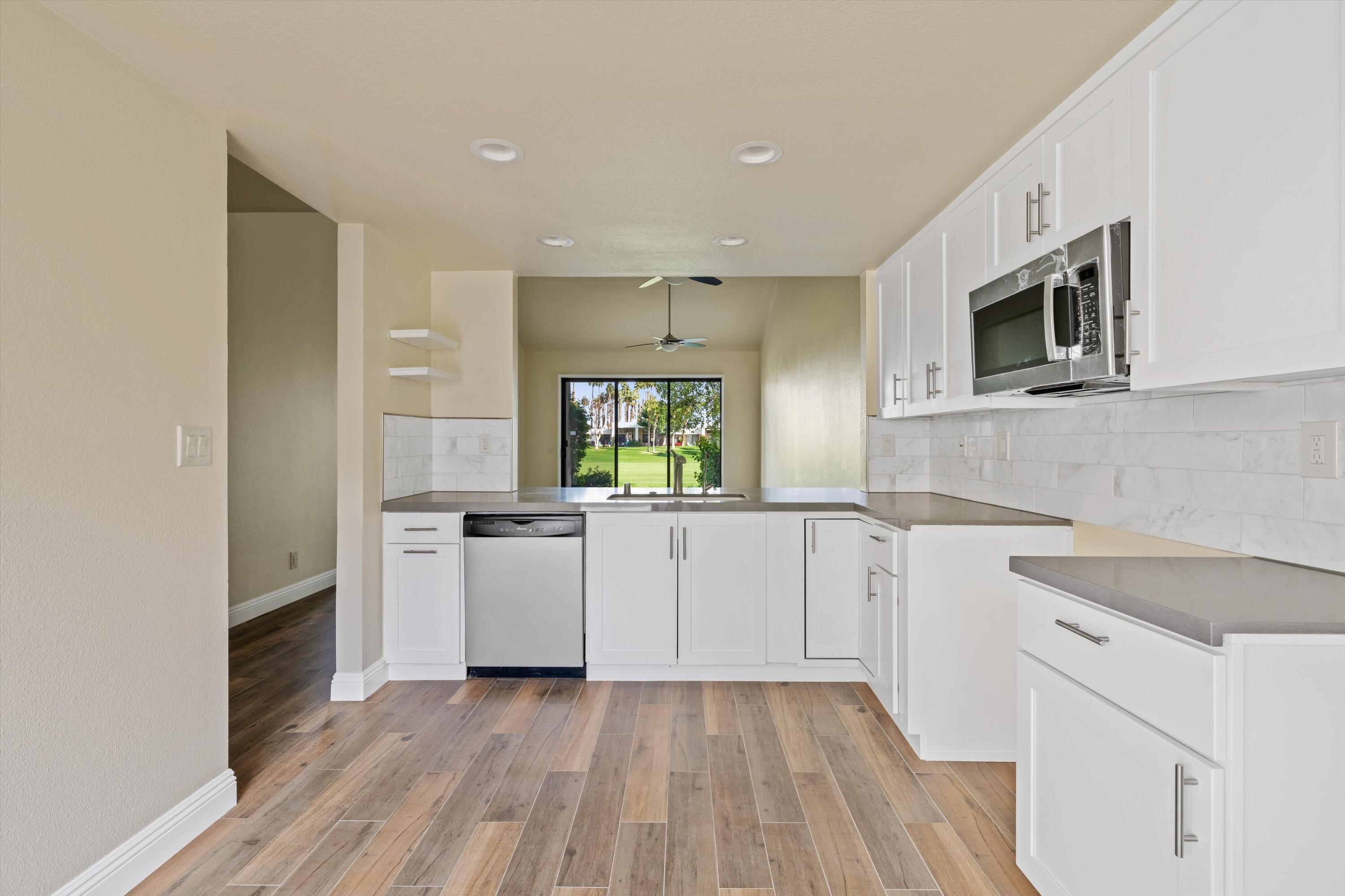 a kitchen with a sink wooden floor and white cabinets