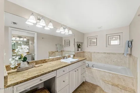 a bathroom with a granite countertop sink mirror and bathtub