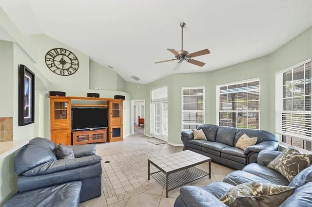 a living room with furniture a flat screen tv and a large window