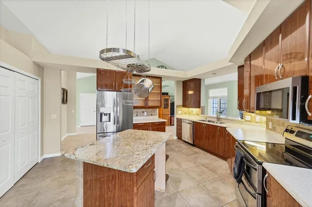 a kitchen with stainless steel appliances granite countertop a sink stove and refrigerator