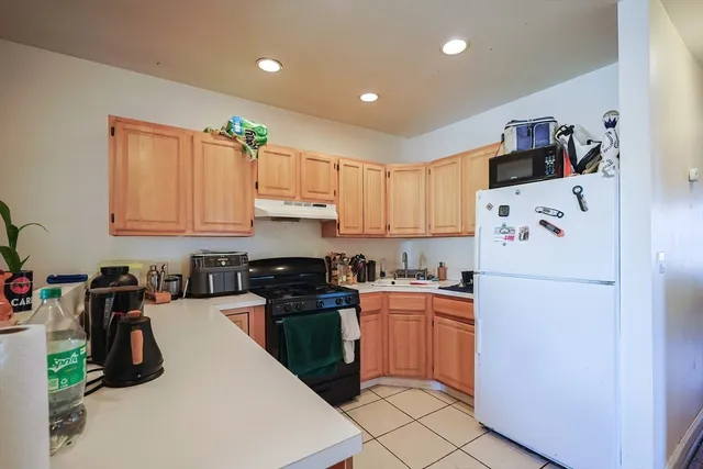 a kitchen with a sink a refrigerator and cabinets