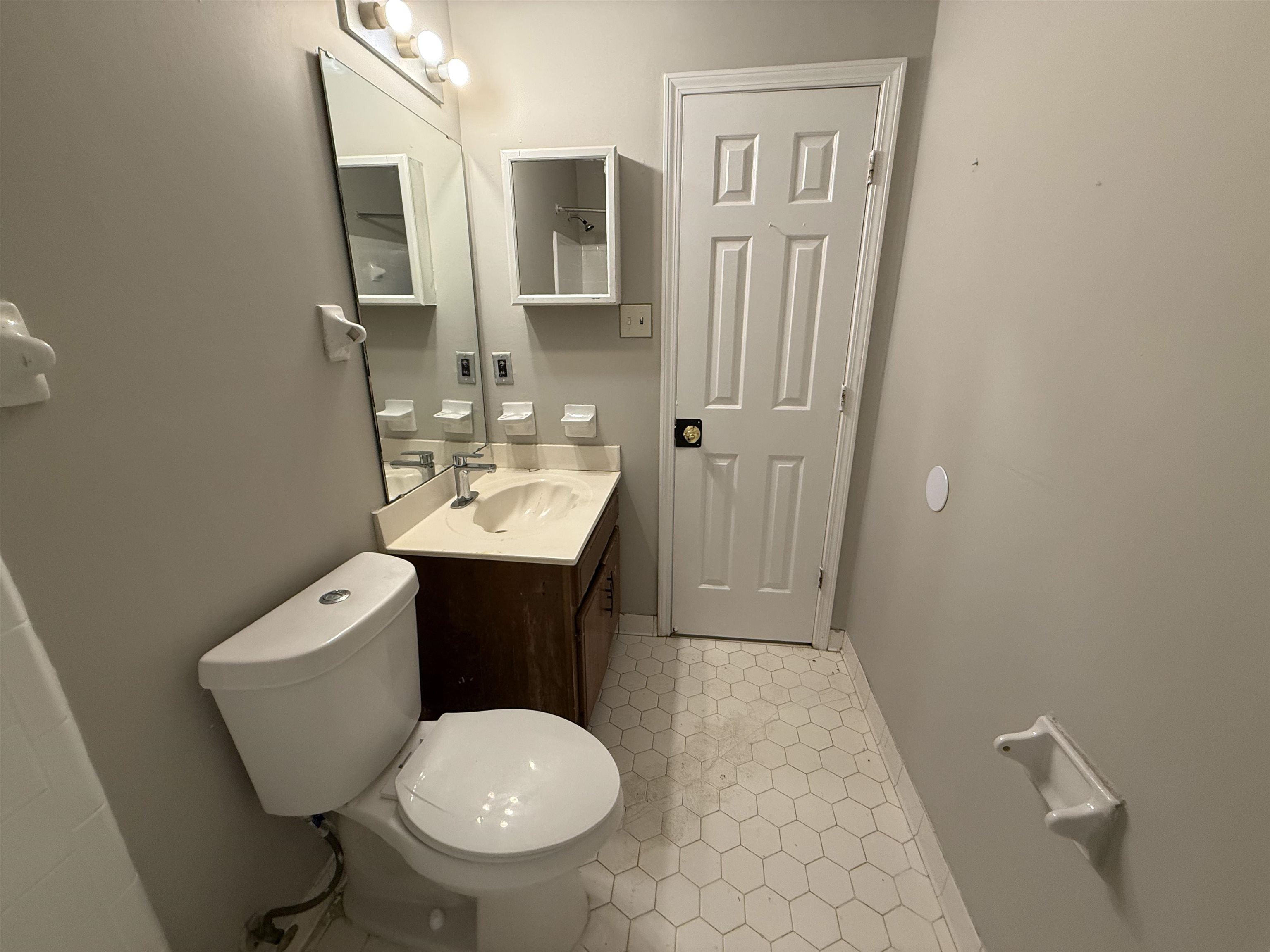 6420 Saginaw Road Memphis, TN 38134 - Photo 16 of 38 Bathroom featuring a hexagonal tile floor, a vanity with a white countertop and integrated sink, a wall-mounted mirror, and a recessed medicine cabinet