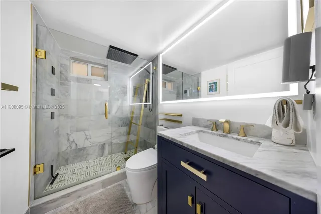 a bathroom with a granite countertop sink a toilet and shower