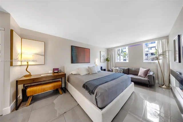 a bedroom with a bed and a dresser next to a window