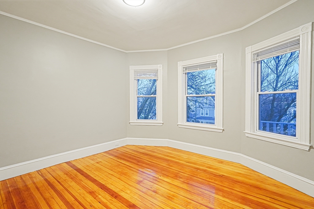 381 Adams Street, Unit 3 Boston, MA 02122 - Photo 15 of 41 a view of an empty room with wooden floor and a window