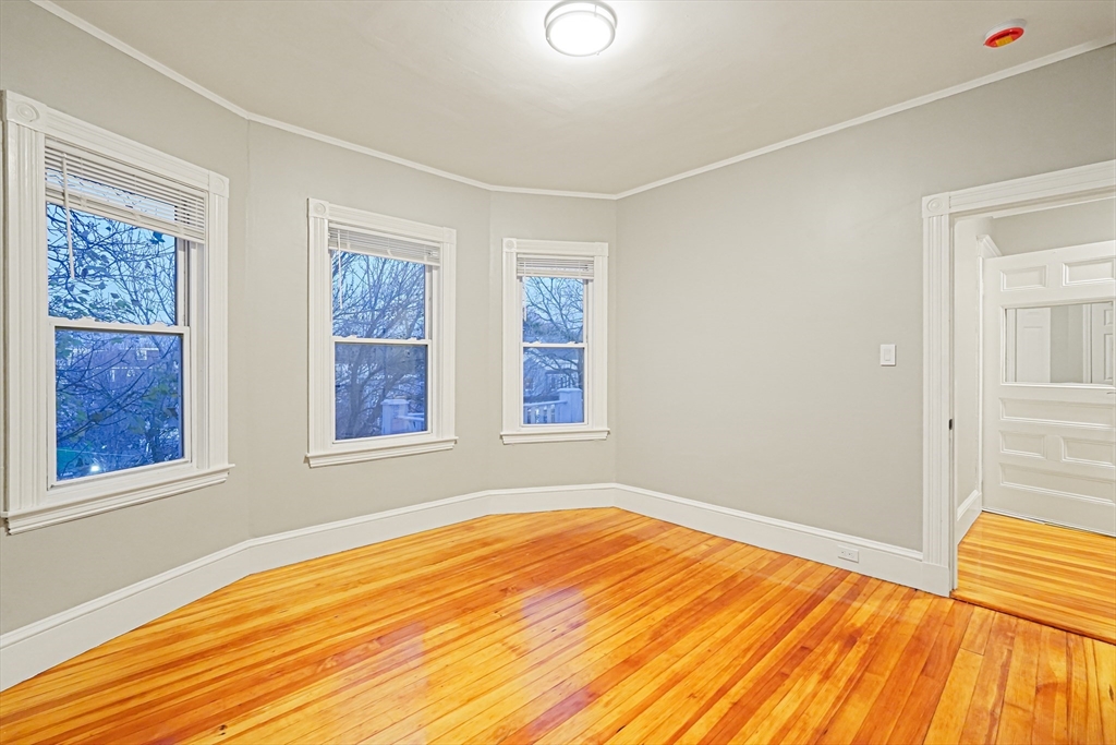 381 Adams Street, Unit 3 Boston, MA 02122 - Photo 16 of 41 a view of an empty room with wooden floor and a window