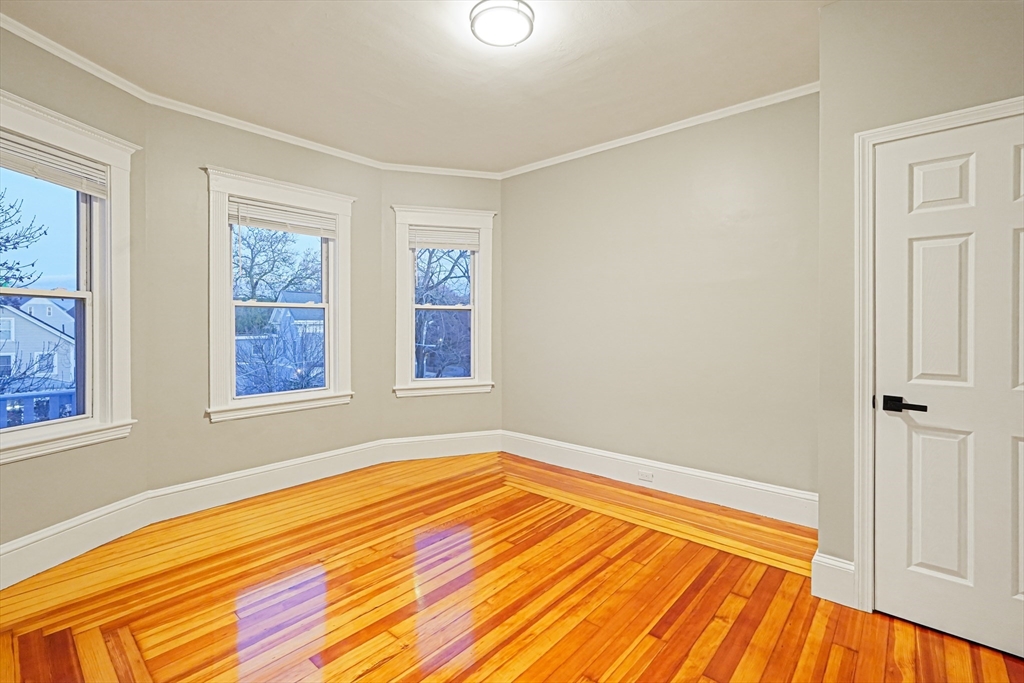 381 Adams Street, Unit 3 Boston, MA 02122 - Photo 20 of 41 a view of empty room with wooden floor and fan