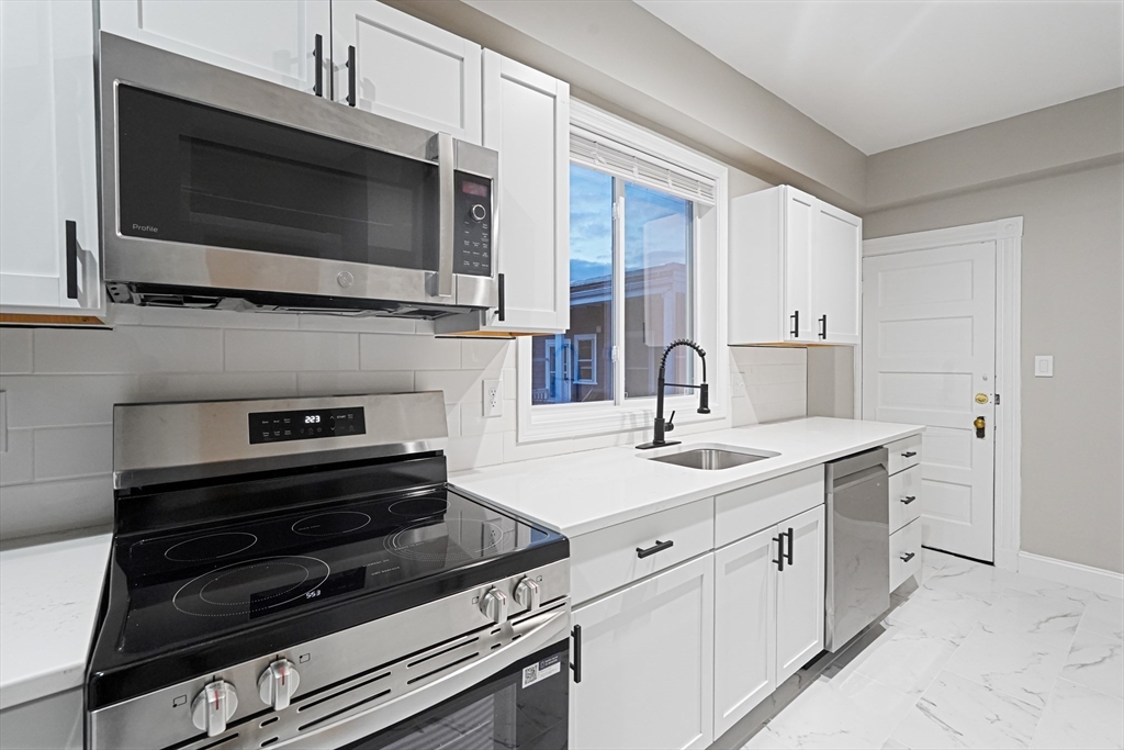 381 Adams Street, Unit 3 Boston, MA 02122 - Photo 5 of 41 a kitchen with a sink and steel appliances