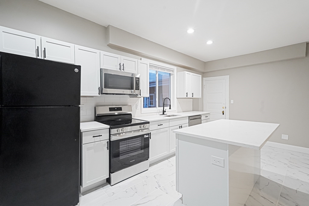 381 Adams Street, Unit 3 Boston, MA 02122 - Photo 6 of 41 a kitchen with a sink stove and refrigerator