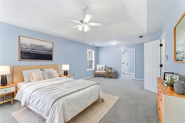a spacious bedroom with a bed a couch and a chandelier