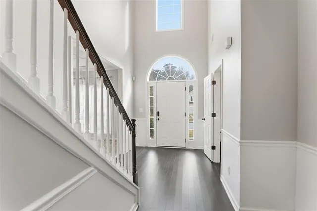 a view of a hallway with wooden floor and staircase