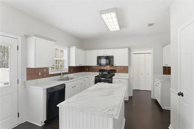 a large white kitchen with cabinets