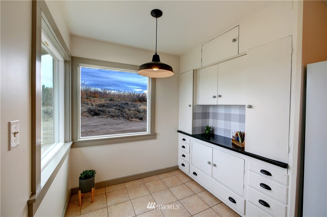 28 Fiker Road Omak, WA 98841 - Photo 11 of 39 a kitchen with granite countertop white cabinets and white appliances