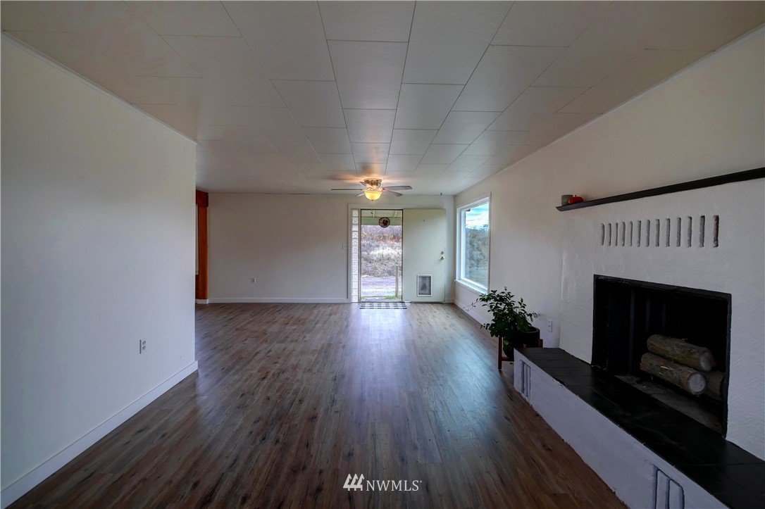 28 Fiker Road Omak, WA 98841 - Photo 4 of 39 wooden floor in an empty room with a fireplace