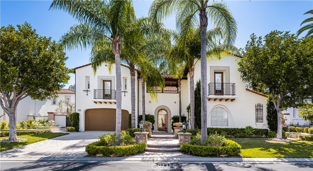 a front view of a house with garden and trees