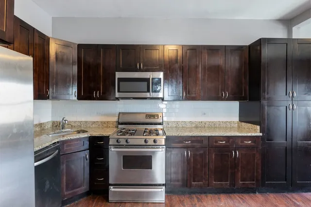 a kitchen with stainless steel appliances wooden cabinets and a stove top oven