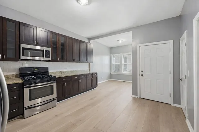 a kitchen with stainless steel appliances granite countertop a stove a sink and a refrigerator