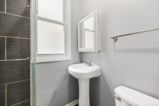 a bathroom with a sink toilet and a mirror