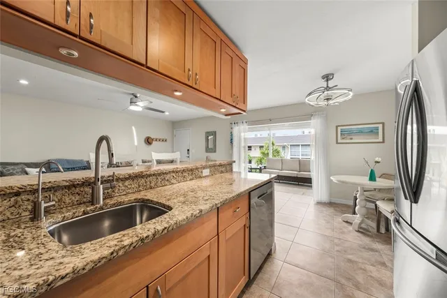 a kitchen with granite countertop a sink and a refrigerator