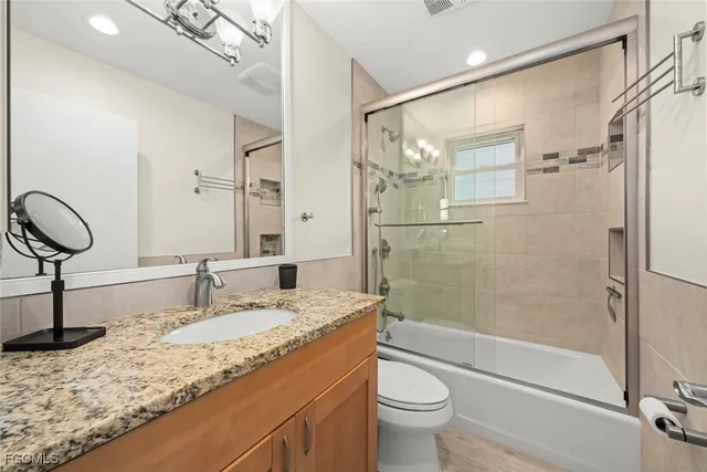 a bathroom with a granite countertop sink toilet and shower