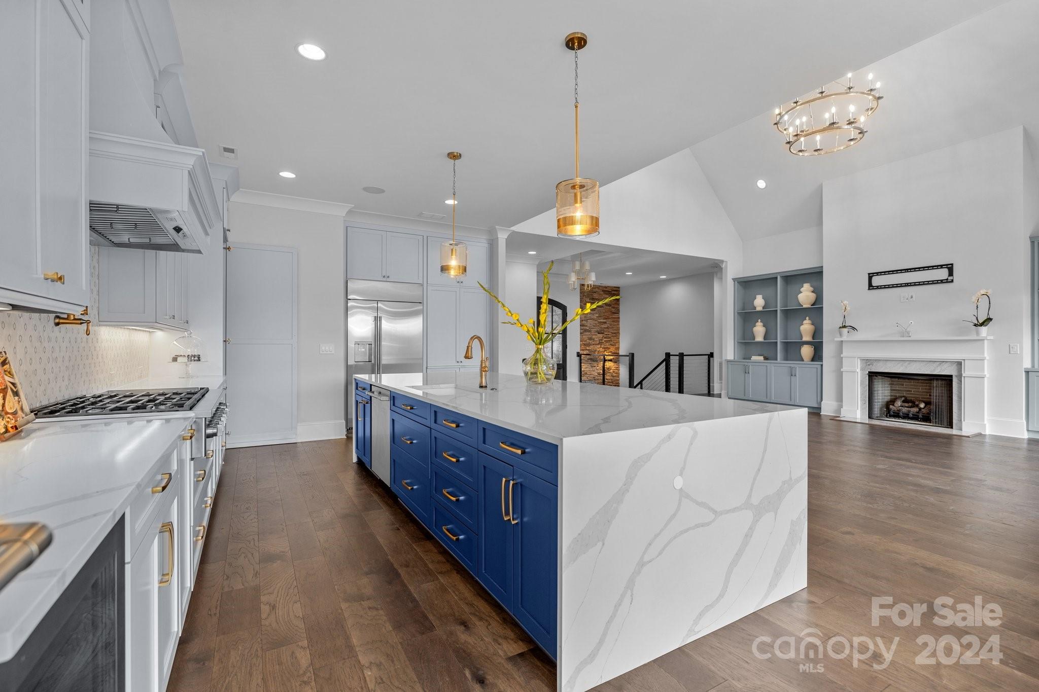 2737 Holbrook Road Fort Mill, SC 29715 - Photo 15 of 46 a large kitchen with stainless steel appliances granite countertop a stove oven a refrigerator a oven and a fireplace with wooden floor