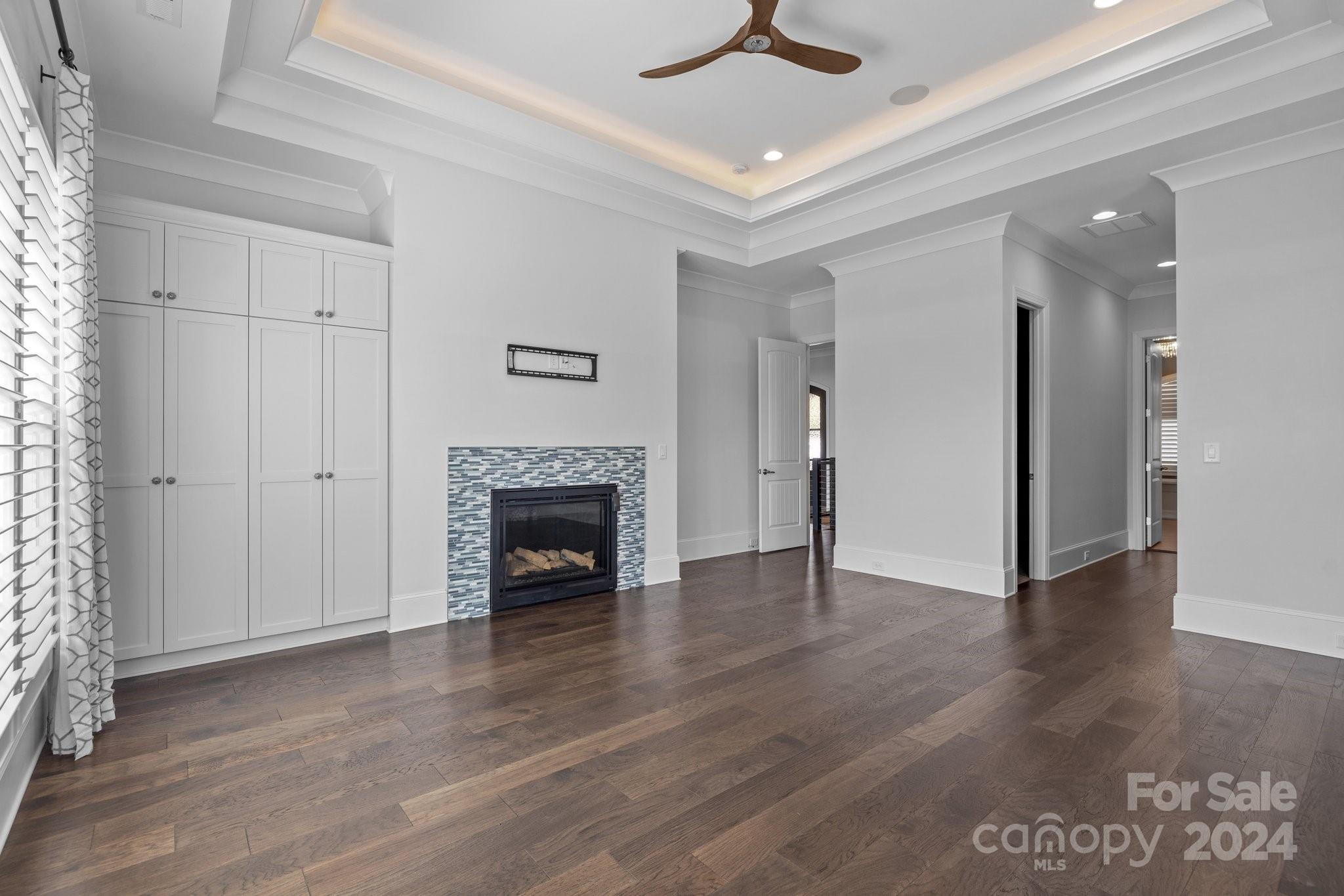 2737 Holbrook Road Fort Mill, SC 29715 - Photo 21 of 46 an empty room with wooden floor a ceiling fan a fireplace and windows