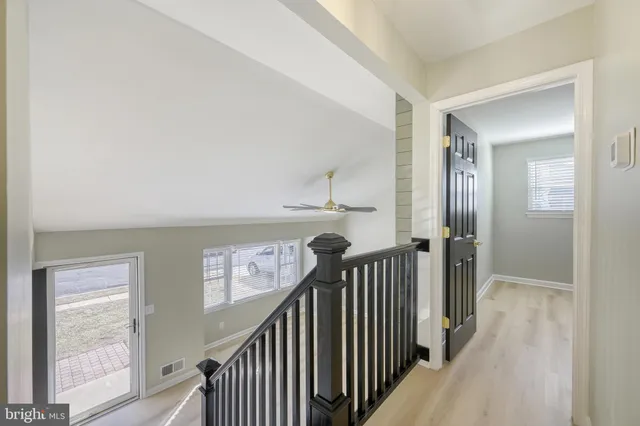 a view of a hallway with wooden floor and stairs